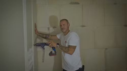Trockenbauer beim Verschrauben einer Gipskartonwand