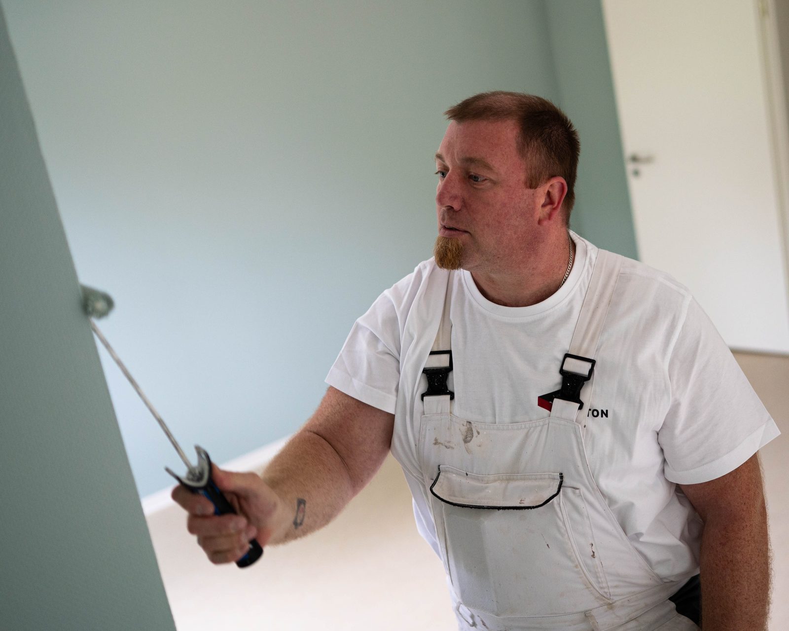 Maler beim Streichen einer Innenwand